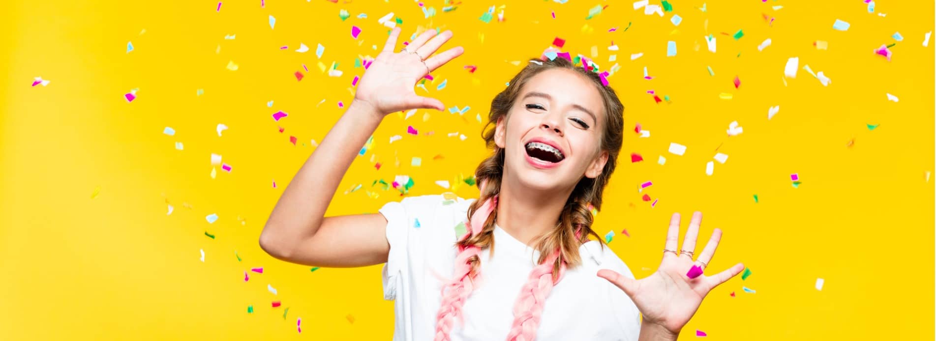 portrait-of-excited-teenage-girl-among-colorful-confetti-picture-id1220419627-min
